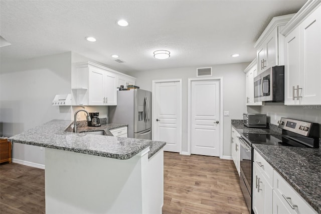14509 Mayer Ave, Hudson, FL 34669 - kitchen with stainless steel appliances, light wood-type flooring, white cabinetry, a peninsula, and recessed lighting