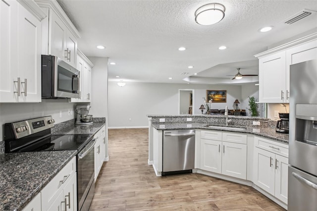 14509 Mayer Ave, Hudson, FL 34669 - kitchen featuring stainless steel appliances, white cabinets, light wood-style flooring, recessed lighting, and a textured ceiling