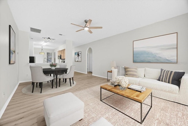 1760 Mountclair Ct, Mount Dora, FL 32757 - living area with arched walkways, light wood finished floors, a ceiling fan, and lofted ceiling