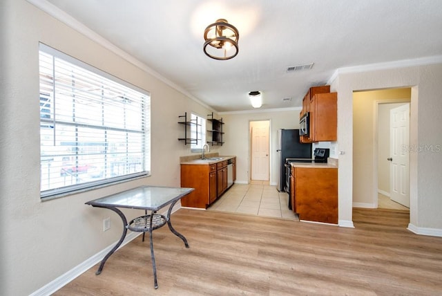200 Country Club Dr Unit 1402, Largo, FL 33771 - kitchen with brown cabinets, stainless steel appliances, ornamental molding, light wood finished floors, and light countertops
