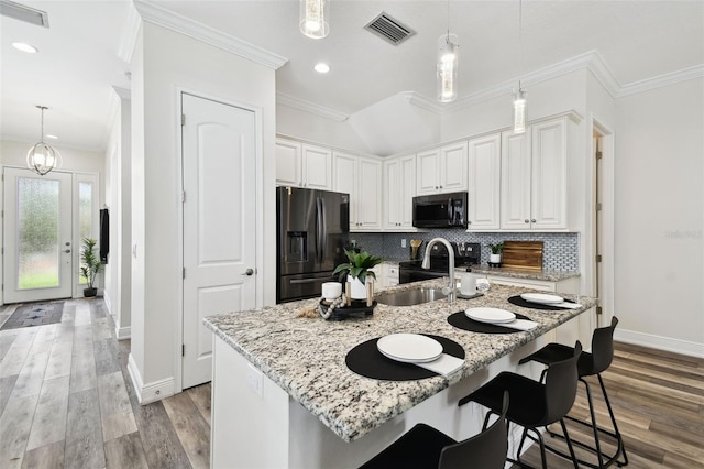 2405 W N B St Unit 1, Tampa, FL 33609 - kitchen with stainless steel fridge, black microwave, ornamental molding, tasteful backsplash, and light stone countertops