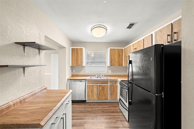 1421 Vinetree Dr, Brandon, FL 33510 - kitchen with appliances with stainless steel finishes, open shelves, a textured wall, dark wood finished floors, and brown cabinets