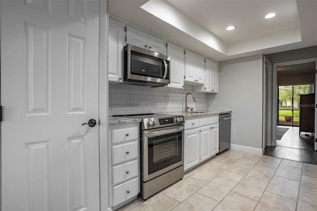 200 Gretchen Ct, Oldsmar, FL 34677 - kitchen featuring appliances with stainless steel finishes, backsplash, white cabinetry, light stone countertops, and recessed lighting