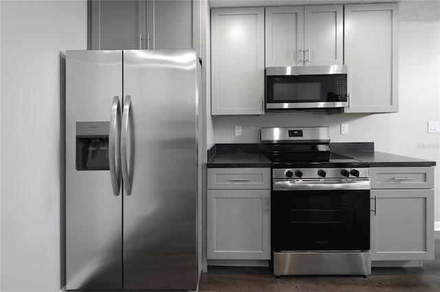 5018 Pine St, Seffner, FL 33584 - kitchen featuring appliances with stainless steel finishes, dark countertops, dark wood-style floors, and gray cabinets