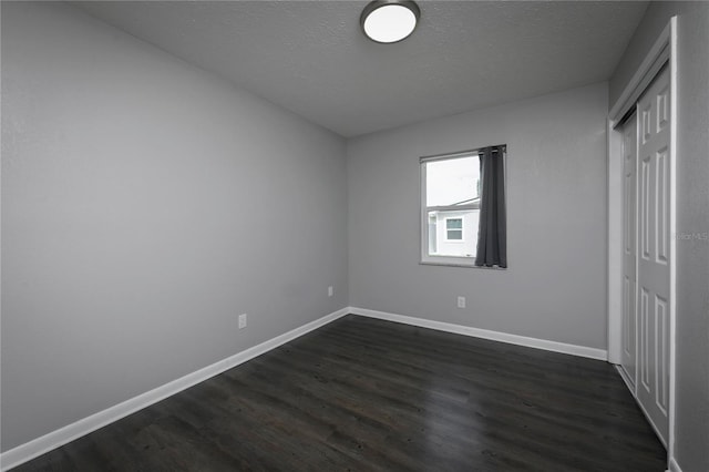 5018 Pine St, Seffner, FL 33584 - unfurnished bedroom with dark wood-style floors, a textured ceiling, and a closet