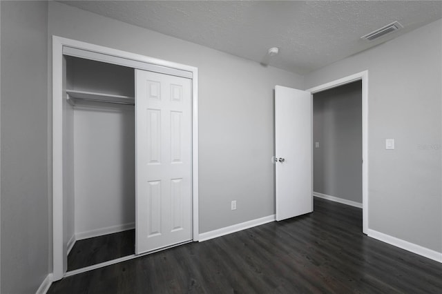5018 Pine St, Seffner, FL 33584 - unfurnished bedroom featuring dark wood-type flooring, a textured ceiling, and a closet