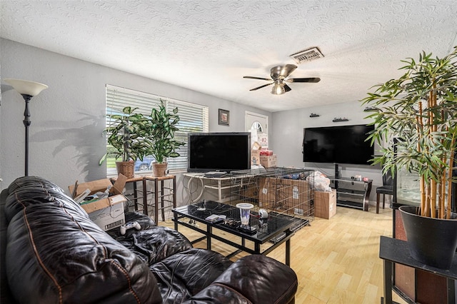 2149 Dixie Garden Loop, Holiday, FL 34690 - living area with wood finished floors, a ceiling fan, and a textured ceiling