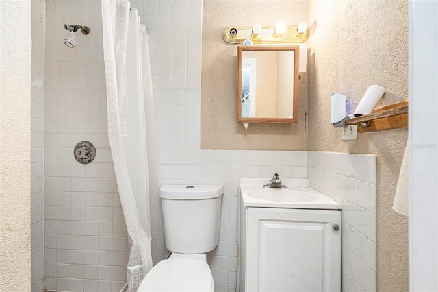 2149 Dixie Garden Loop, Holiday, FL 34690 - full bathroom featuring tile walls, vanity, tiled shower, wainscoting, and a textured wall
