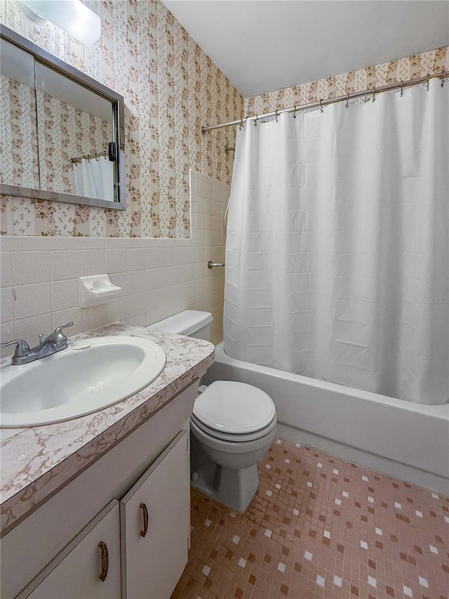 2460 Persian Dr Unit 44, Clearwater, FL 33763 - full bath with vanity, shower / bath combo with shower curtain, wallpapered walls, a wainscoted wall, and tile walls