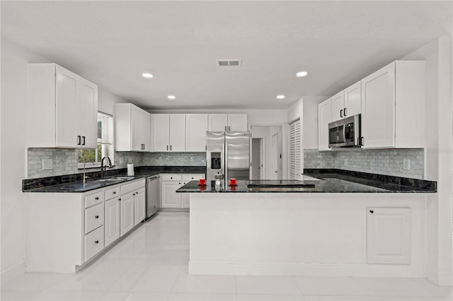 210 Lake Hobbs Rd, Lutz, FL 33548 - kitchen featuring appliances with stainless steel finishes, a peninsula, backsplash, recessed lighting, and white cabinetry