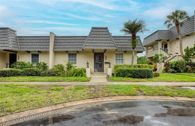 2206 Cordova Grn Unit 2206, Seminole, FL 33777 - view of front of house featuring mansard roof and stucco siding