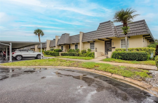 2206 Cordova Grn Unit 2206, Seminole, FL 33777 - view of property featuring mansard roof and stucco siding