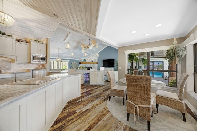 6605 Seabird Way, Apollo Beach, FL 33572 - dining area featuring light wood-style flooring, wine cooler, recessed lighting, and a chandelier
