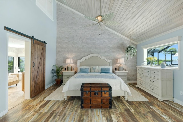 6605 Seabird Way, Apollo Beach, FL 33572 - bedroom featuring brick wall, lofted ceiling, wood finished floors, a barn door, and ensuite bath