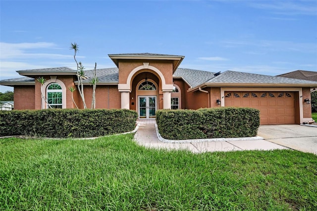 3612 Covington Dr, Holiday, FL 34691 - view of front facade featuring an attached garage, driveway, a front yard, stucco siding, and french doors