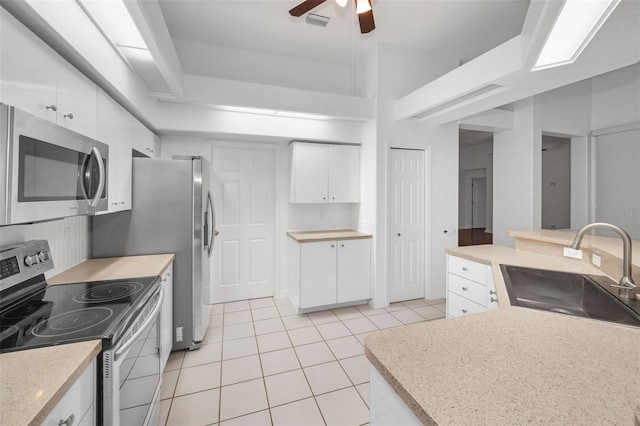 3612 Covington Dr, Holiday, FL 34691 - kitchen featuring stainless steel appliances, light tile patterned floors, a ceiling fan, white cabinetry, and light countertops