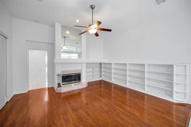 3612 Covington Dr, Holiday, FL 34691 - unfurnished living room with a ceiling fan, wood finished floors, a glass covered fireplace, built in features, and recessed lighting