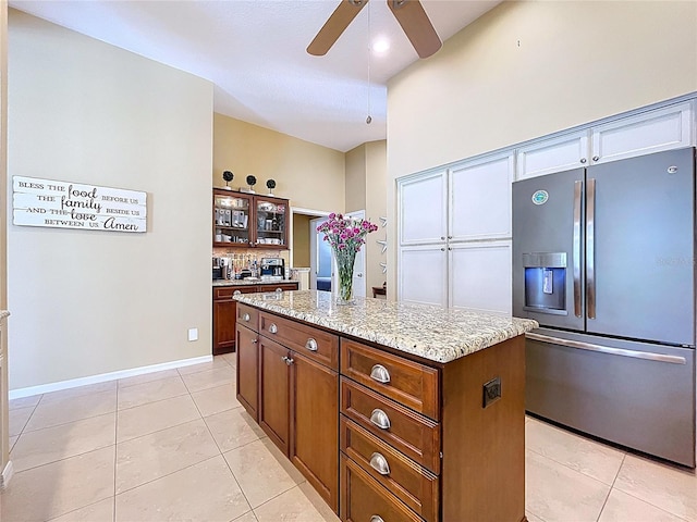 1358 Forestedge Blvd, Oldsmar, FL 34677 - kitchen with stainless steel refrigerator with ice dispenser, a ceiling fan, light tile patterned floors, a center island, and backsplash