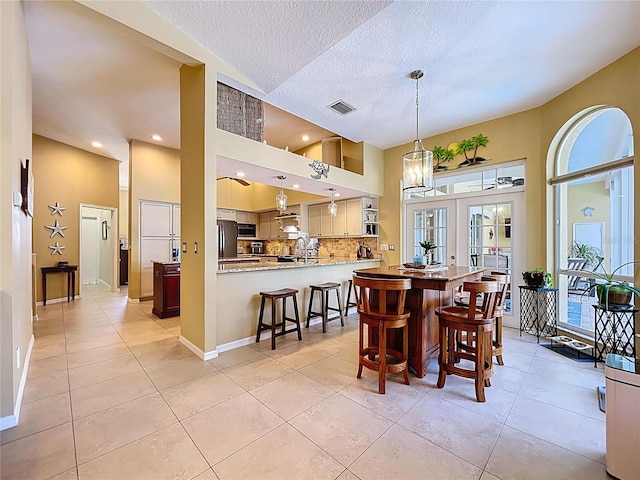 1358 Forestedge Blvd, Oldsmar, FL 34677 - dining room with light tile patterned flooring, a textured ceiling, recessed lighting, and a towering ceiling