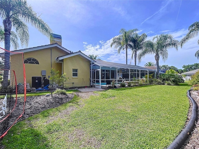 1358 Forestedge Blvd, Oldsmar, FL 34677 - rear view of house with stucco siding, a yard, a chimney, and glass enclosure