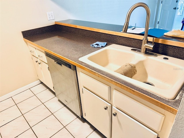 2525 W Bay Dr Unit A33, Largo, FL 33770 - kitchen with dishwasher, light tile patterned floors, dark countertops, and white cabinets