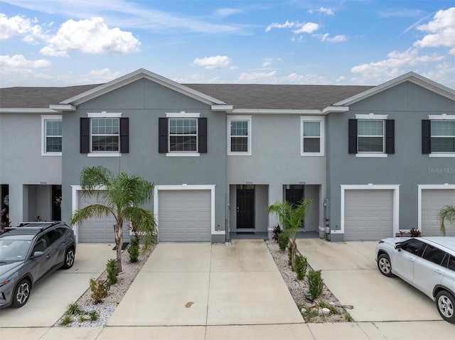 33036 Frosted Clover Way, Wesley Chapel, FL 33545 - townhome / multi-family property featuring driveway, an attached garage, stucco siding, and a shingled roof