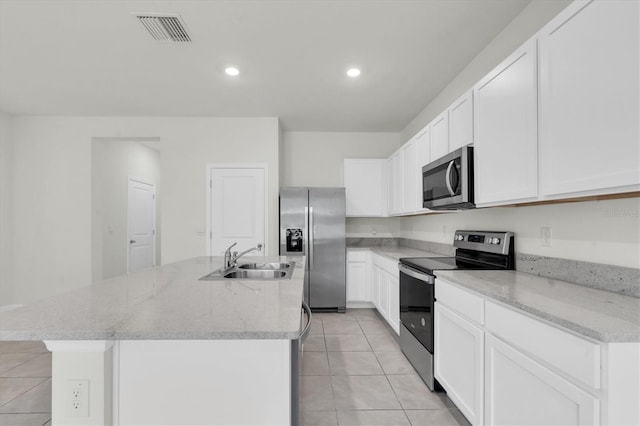 33036 Frosted Clover Way, Wesley Chapel, FL 33545 - kitchen featuring appliances with stainless steel finishes, light tile patterned floors, a center island with sink, white cabinets, and recessed lighting