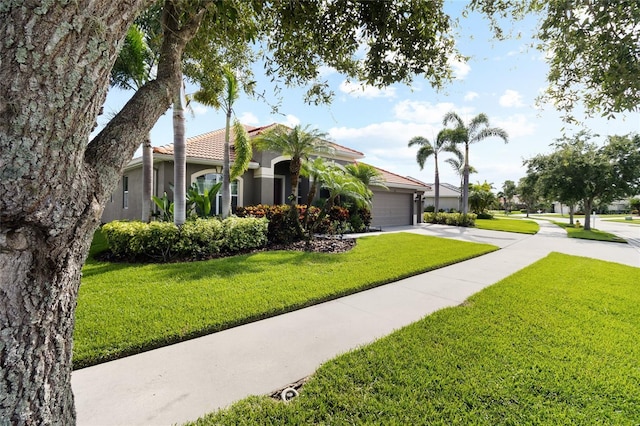 317 Royal Bonnet Dr, Apollo Beach, FL 33572 - view of front facade featuring concrete driveway, an attached garage, a tiled roof, a front yard, and stucco siding