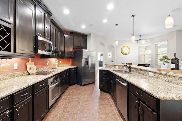 317 Royal Bonnet Dr, Apollo Beach, FL 33572 - kitchen with stainless steel appliances, arched walkways, light stone countertops, hanging light fixtures, and recessed lighting