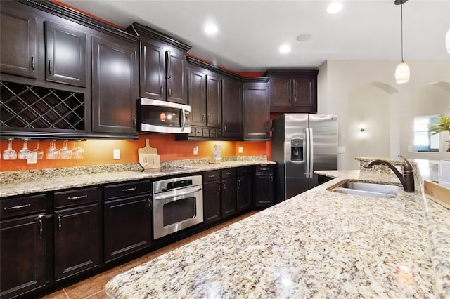 317 Royal Bonnet Dr, Apollo Beach, FL 33572 - kitchen with appliances with stainless steel finishes, arched walkways, light stone countertops, hanging light fixtures, and recessed lighting