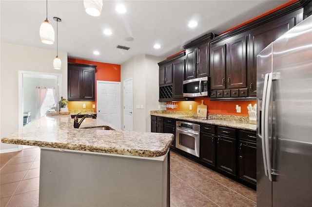 317 Royal Bonnet Dr, Apollo Beach, FL 33572 - kitchen featuring stainless steel appliances, tile patterned floors, light stone countertops, pendant lighting, and recessed lighting