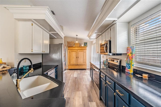 2208 Cattleman Dr, Brandon, FL 33511 - kitchen featuring appliances with stainless steel finishes, blue cabinets, white cabinets, dark countertops, and light wood-style flooring