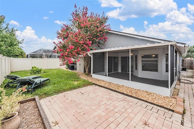 2208 Cattleman Dr, Brandon, FL 33511 - back of house with a sunroom, a fenced backyard, and a patio