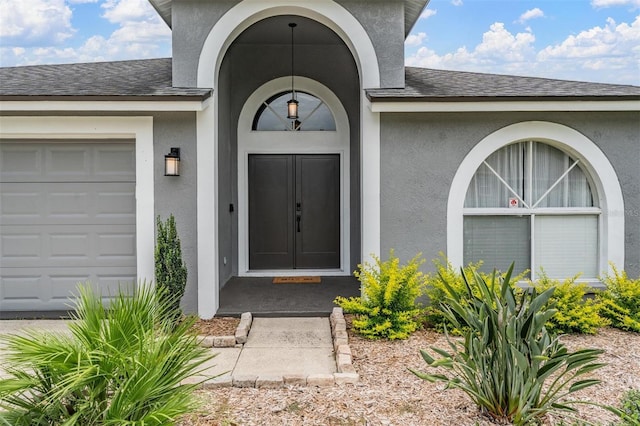 2208 Cattleman Dr, Brandon, FL 33511 - view of exterior entry with stucco siding, a garage, and roof with shingles