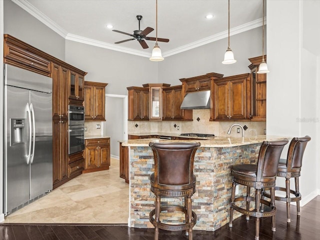 4521 Cheval Blvd, Lutz, FL 33558 - kitchen with appliances with stainless steel finishes, under cabinet range hood, ceiling fan, a peninsula, and ornamental molding