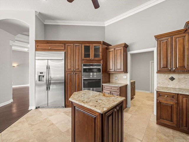 4521 Cheval Blvd, Lutz, FL 33558 - kitchen with appliances with stainless steel finishes, backsplash, a ceiling fan, light stone countertops, and ornamental molding