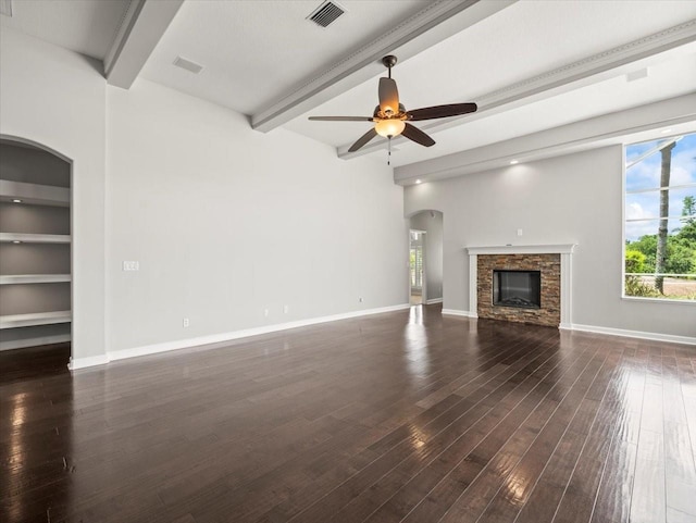 4521 Cheval Blvd, Lutz, FL 33558 - unfurnished living room featuring beam ceiling, ceiling fan, a stone fireplace, dark wood finished floors, and arched walkways