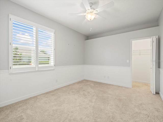 4521 Cheval Blvd, Lutz, FL 33558 - unfurnished bedroom featuring a walk in closet, carpet floors, a closet, wainscoting, and a ceiling fan