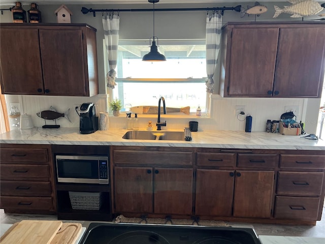 4119 Chambers St, Lake Wales, FL 33898 - kitchen with stainless steel microwave, light countertops, decorative light fixtures, and dark brown cabinets