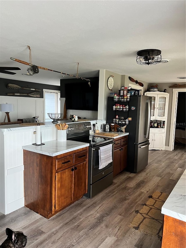 4119 Chambers St, Lake Wales, FL 33898 - kitchen with electric range, dark wood-style flooring, brown cabinets, a peninsula, and freestanding refrigerator