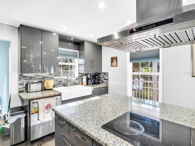 4915 S Rd, New Port Richey, FL 34652 - kitchen with wall chimney exhaust hood, black electric cooktop, dishwasher, gray cabinetry, and tasteful backsplash