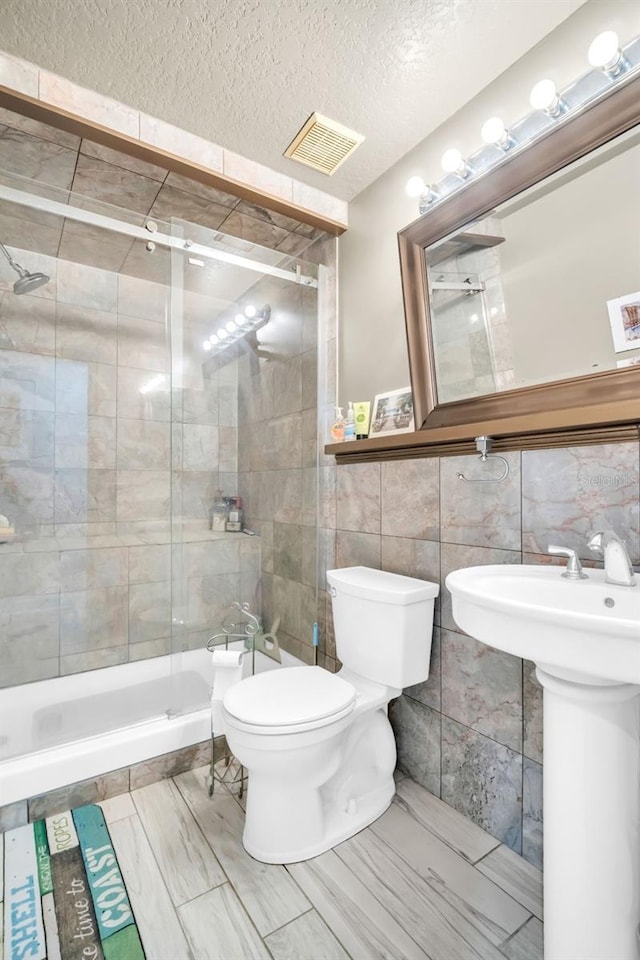 4915 S Rd, New Port Richey, FL 34652 - bathroom with tile walls, a shower stall, and a textured ceiling
