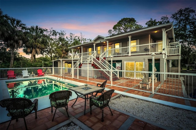4915 S Rd, New Port Richey, FL 34652 - back of property at dusk with stairs, a patio, and a balcony