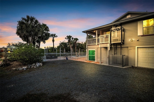 4915 S Rd, New Port Richey, FL 34652 - back of property at dusk with a balcony and a gate