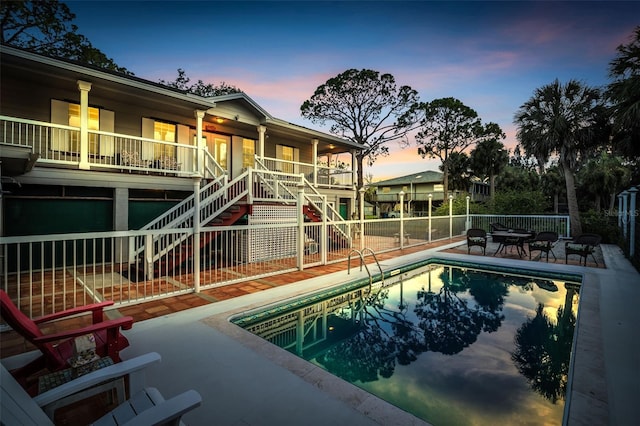 4915 S Rd, New Port Richey, FL 34652 - pool at dusk featuring stairway, a fenced backyard, and a patio area