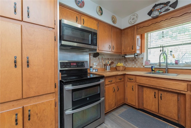 33 Cypress Dr, Palm Harbor, FL 34684 - kitchen featuring stainless steel appliances, decorative backsplash, light countertops, and brown cabinetry