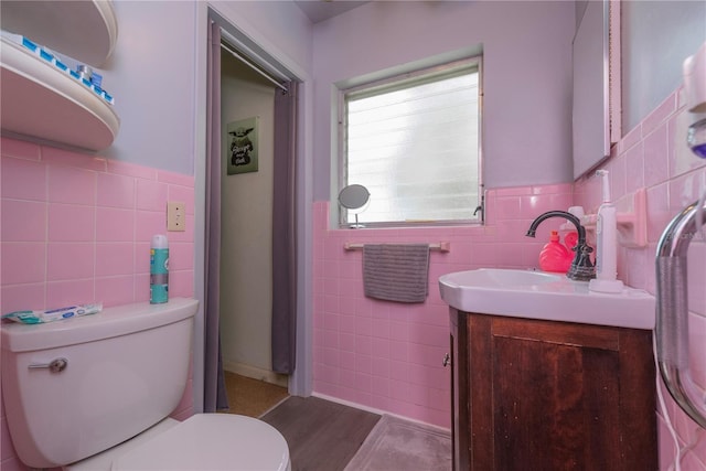 33 Cypress Dr, Palm Harbor, FL 34684 - bathroom with tile walls, vanity, a wainscoted wall, and wood finished floors