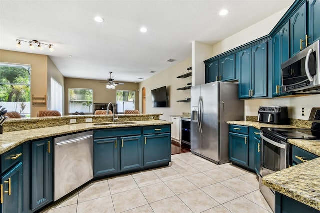 2009 Raven Manor Dr, Dover, FL 33527 - kitchen featuring stainless steel appliances, blue cabinets, ceiling fan, light tile patterned floors, and light stone countertops