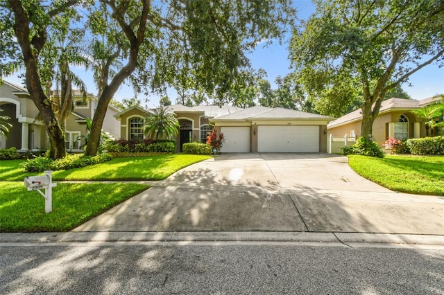 2009 Raven Manor Dr, Dover, FL 33527 - ranch-style house with concrete driveway, a garage, a front yard, and stucco siding