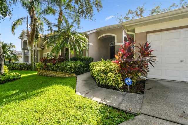 2009 Raven Manor Dr, Dover, FL 33527 - view of front of house with a front yard, a garage, and stucco siding